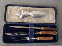 Open case showing knife, fork, steel and torso figure