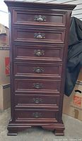 Front view of tall seven-drawer mahogany chest showing hardware and feet