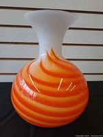 Front view of orange and white swirl striped glass vase