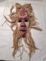 Full view of wooden mask with jute fibers