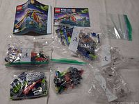 Overall view: instruction manuals, multiple numbered LEGO bags including re-bagged parts