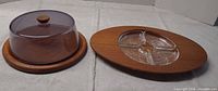 Round cheese board with dome and oval tray with glass insert side by side