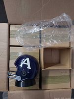 Box containing several individually boxed helmet radios with one unit displayed