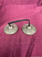 Front view of both brass Tingsha cymbals connected by cord