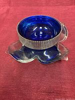Bowl seated in metal stand, side view showing lattice band and petal base