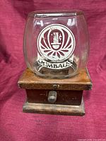 Frontal view showing glass globe, decal, and wooden base