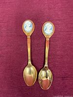 Two gold-plated spoons side by side showing overall design