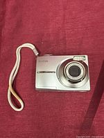 Front view of Kodak silver digital camera with lens extended ring and flash visible