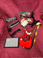 Assorted partially built guitar body, neck, amp pieces, strap, cable, loose bricks