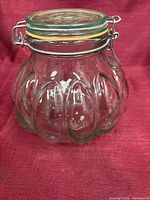Front angled view of ribbed glass jar with clamp lid
