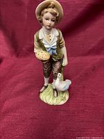 Front view of porcelain boy figurine with dove and bread