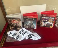 Front view of three PS3 game cases and pair of socks