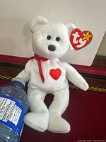 Full view of Valentino Beanie Baby with tags and size reference bottle