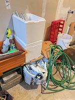 Overall lot showing hose, soil bags, planters, Styrofoam coolers, bucket, red rack and accessories
