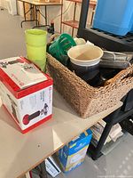 Boxed Outbound propane stove, stacked cups, wicker basket with kitchenware