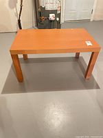 Full view of rectangular veneer coffee table showing top, legs and overall design