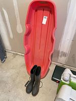 Boots leaning against red sled