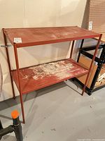 Full view of red metal two-shelf wall unit