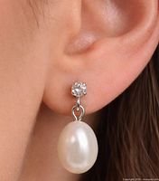 Earring worn on ear showing diamond stud and pearl drop
