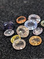 Group of loose faceted multicolor sapphires on black background