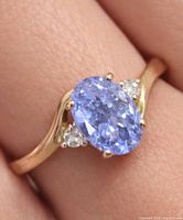 Ring on finger showing tanzanite and diamonds