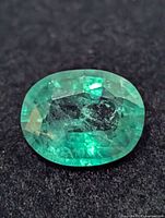Close-up of oval emerald gemstone showing color and cut
