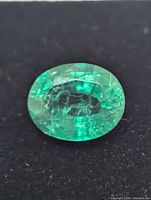 Close-up of oval green created emerald gemstone top view