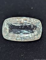 Close-up of faceted aquamarine surface and inclusions