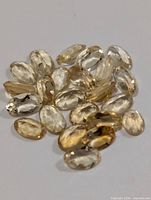 Group of oval faceted citrine gemstones on plain background