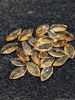 Group of loose marquise-cut citrine gemstones on black background