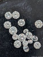 Close-up of loose diamonds on dark background showing cuts and clarity