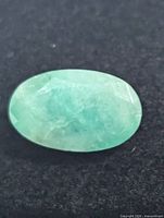 close-up of loose oval emerald gemstone