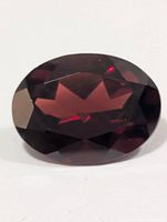 Front view of oval faceted garnet showing crown facets and deep red color