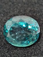 Close-up of the oval faceted green topaz showing facets and color