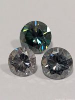 Front view of three round brilliant moissanite stones