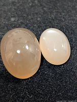 Two moonstone cabochons close-up, showing size difference and translucent color