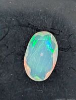 Top view of oval faceted opal showing play-of-colour