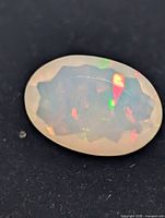 oval faceted opal showing play of colour