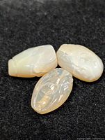 Three carved opal beads on dark background