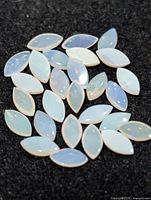 Group of marquise opal cabochons on black background
