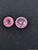 Close-up of two round pink sapphires on dark background