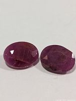 Two oval rubies, facets visible