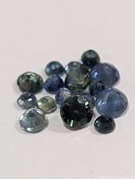 Front angled view of loose sapphires showing colour variation and cuts