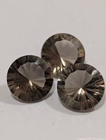 Front view of three round smoky quartz gems