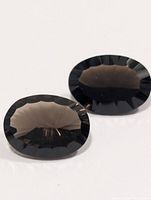 Pair of oval faceted dark Smokey Quartz gemstones, angled view