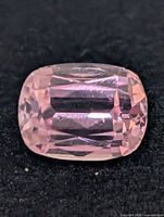 Close-up of pale pink rectangular cushion-cut kunzite on black background