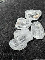 Four rough clear quartz crystals on black background