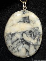 Front view of oval dendritic opal pendant in silver bezel
