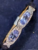 Close-up of ring top showing two tanzanite ovals and topaz accents