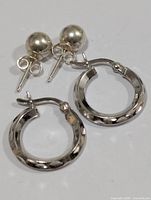 Pair of silver ball stud earrings and pair of small patterned hoops